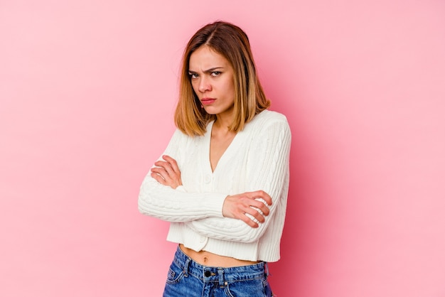 ピンクの背景にポーズをとって若い女性