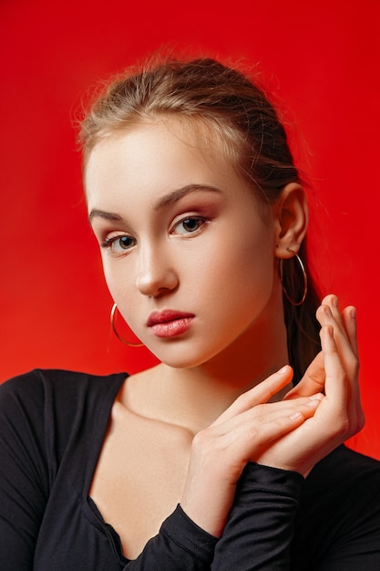 Young woman posing over red wall