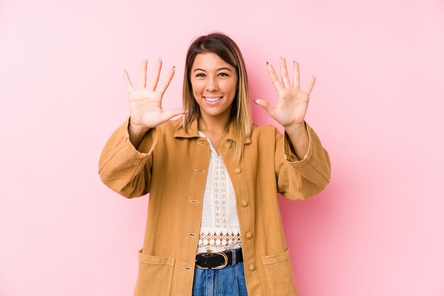 Young woman posing showing number ten with hands.