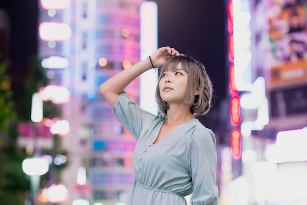 Young woman posing in Tokyo city at night