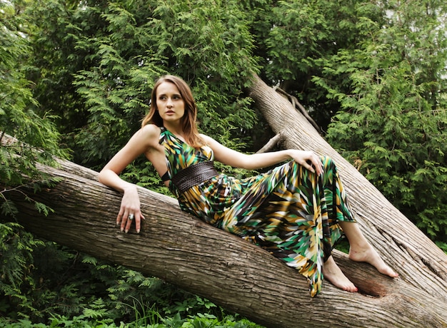 Young woman posing on a tree