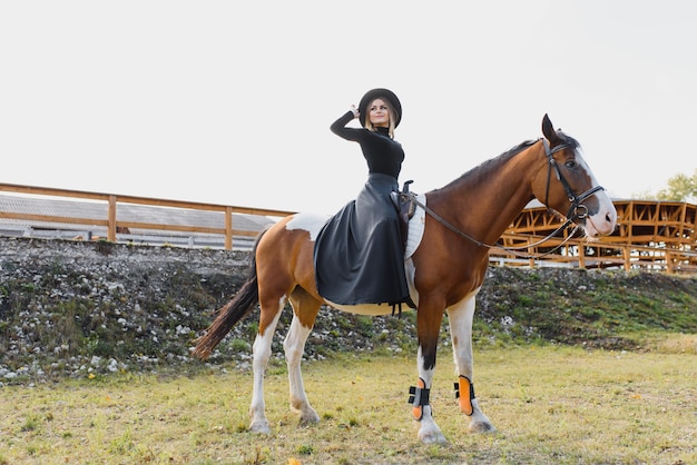 Молодая женщина позирует с лошадью