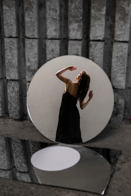 Photo young woman posing with mirror creating beautiful reflections