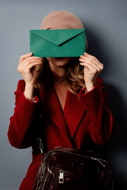 Young woman postman with green envelope