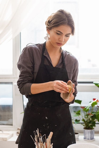 若い女性の陶芸家が皿を作る土鍋