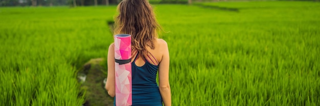 Giovane donna pratica yoga all'aperto nelle risaie al mattino durante il ritiro benessere a bali