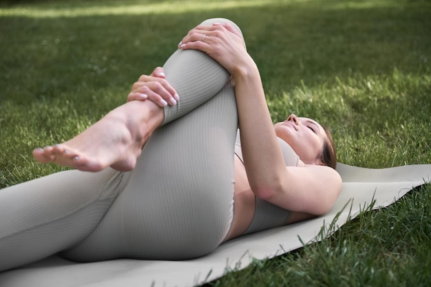 A young woman practices yoga in the park