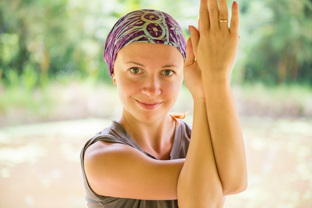 Giovane donna che pratica garudasana