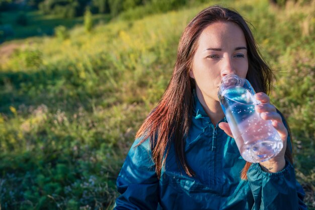 Giovane donna che pratica acqua potabile stile di vita sano all'aperto