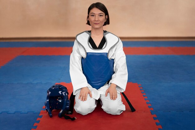 Foto giovane donna che pratica il taekwondo in una palestra