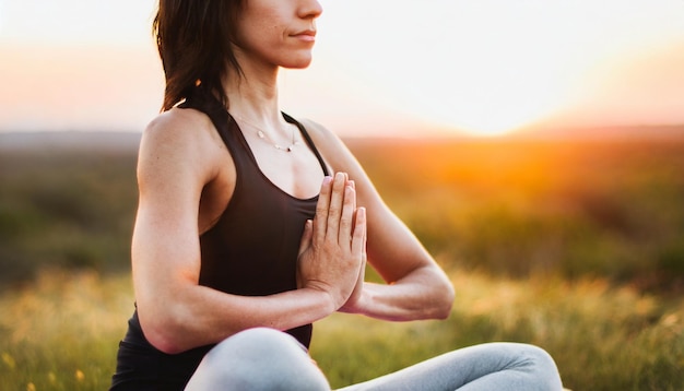 young woman practicing yoga against a vibrant sunset embodying freedom and wellness in nature's emb