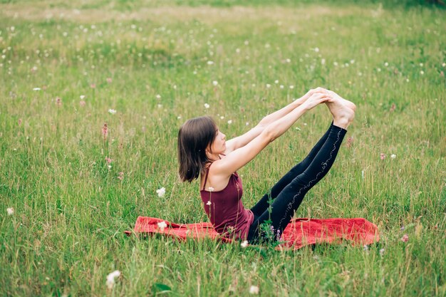 Photo young woman practicing yoga, does morning exercises, gymnastics