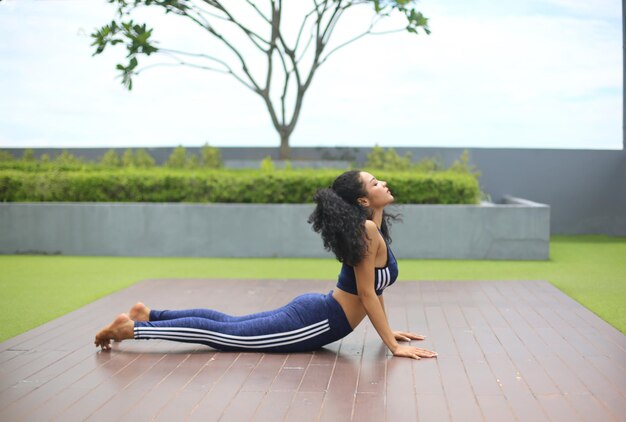 Young woman practicing yoga in a gym working out in black sportswear