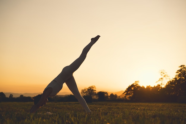 Young woman practicing yoga on nature Girl meditating outdoors