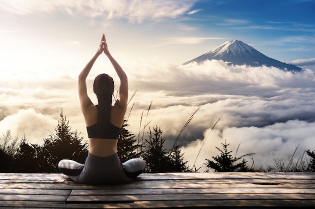 Foto yoga di pratica della giovane donna nella natura