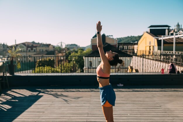 Young woman practicing yoga on the roof of a building