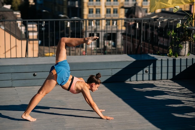 Young woman practicing yoga on the roof of a building