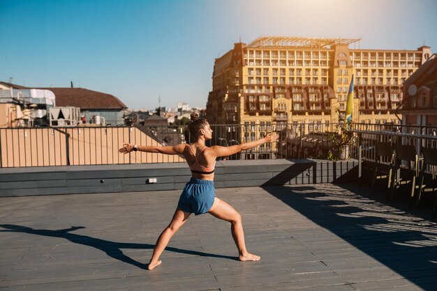 Young woman practicing yoga on the roof of a building