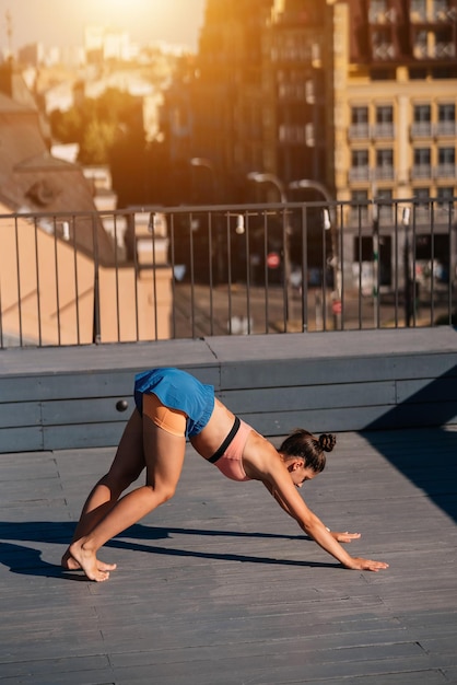 Young woman practicing yoga on the roof of a building