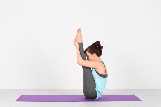 Young woman practicing yoga on white