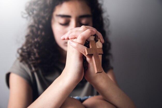 Photo young woman praying with holy wooden cross