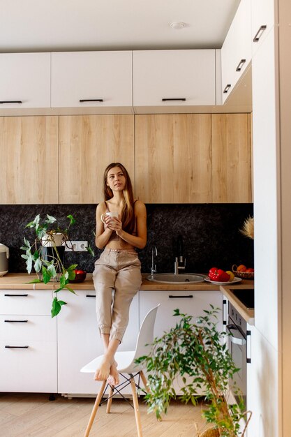 A young woman prepares vegetable salad at home Vegan cuisine