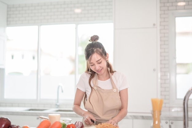 Photo young woman preparing food in kitchen at home