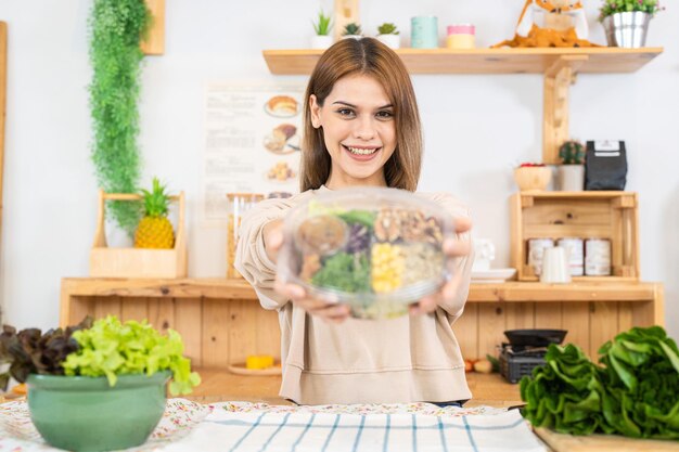 Young woman preparing healthy food with salad vegetables woman sitting at pantry in a beautiful interior kitchen The clean diet food from local products and ingredients Market fresh