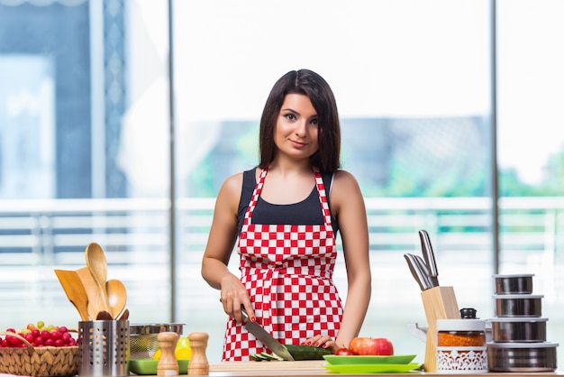 Young woman preparing salad in the kitchen