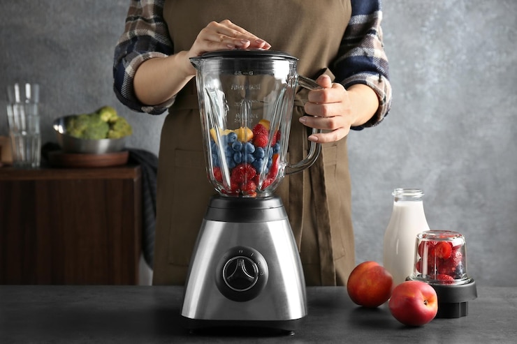 Photo young woman preparing smoothie in kitchen