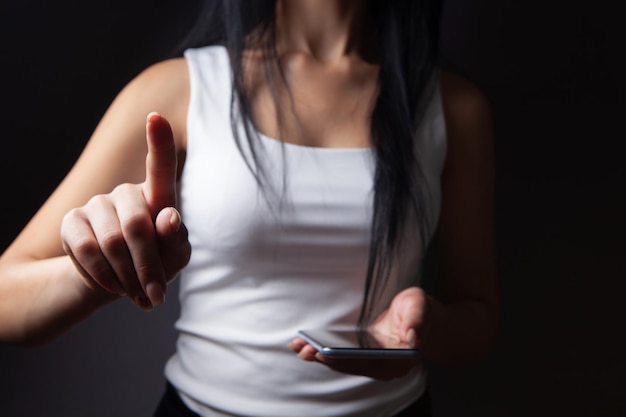 Young woman pressing the screen while holding the phone