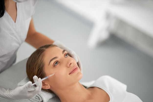 Photo young woman on procedure antiaging in beauty salon