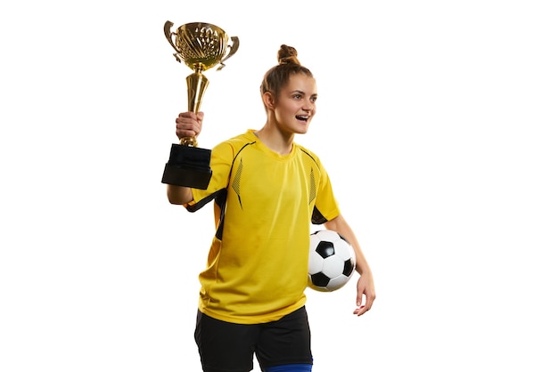 Young woman professional female football soccer player in yellow uniform posing with trophy and