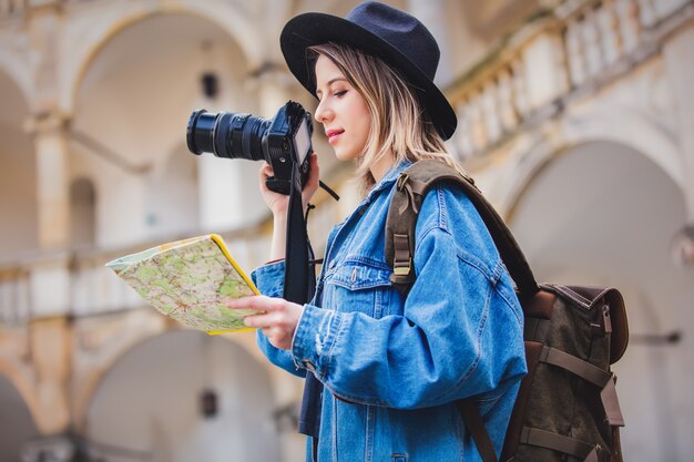 Young woman, professional photographer with camera in old castle. Traveler concept