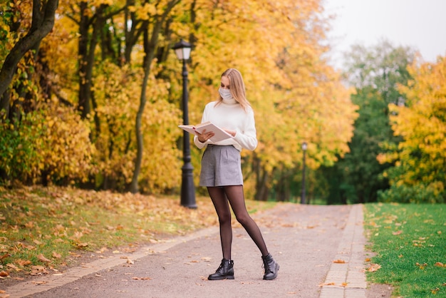 A young woman protecting from corona virus when walking in park