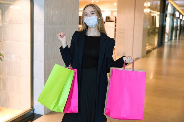 A young woman in a protective mask in a shopping center