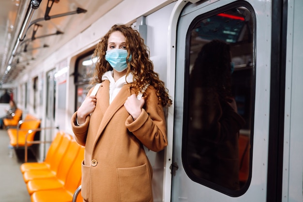 Young woman in protective sterile medical mask in the subway car