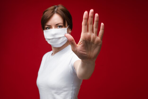 Young woman in protective suit making gesture protection by hand