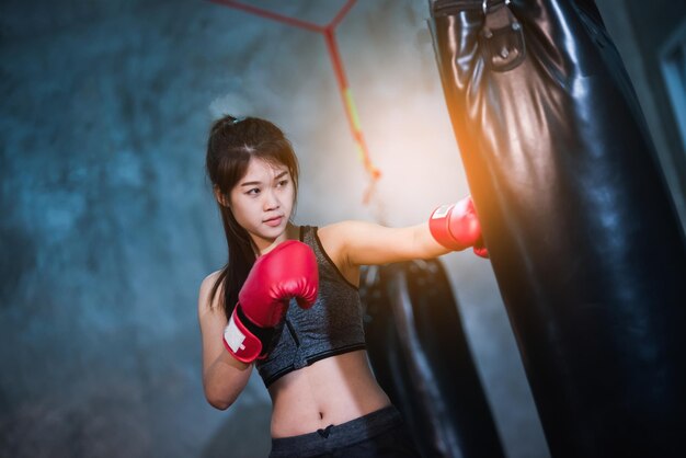체육관 에서 권투 가방 을 때리는 젊은 여자