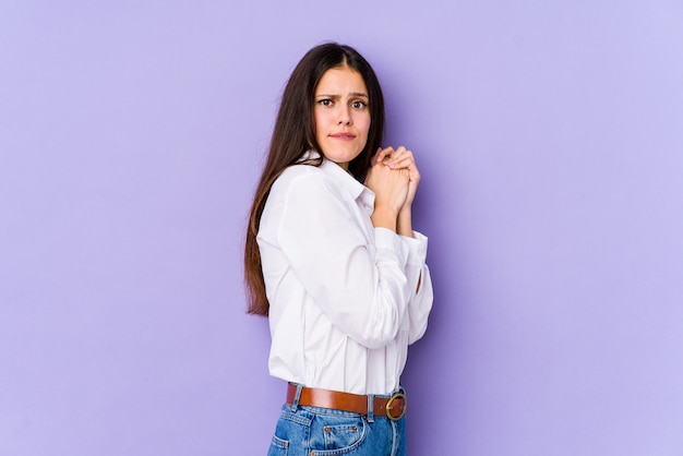 Young woman on purple scared and afraid.