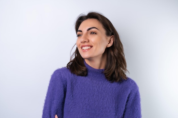 Young woman in a purple soft cozy sweater on the background of cute smiling cheerfully in high spirits confident smilex9