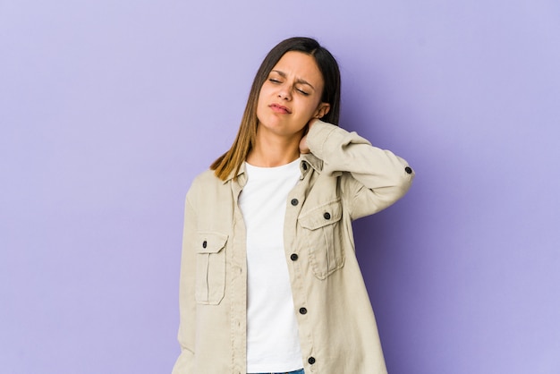 Foto giovane donna sulla parete viola che soffre di dolore al collo