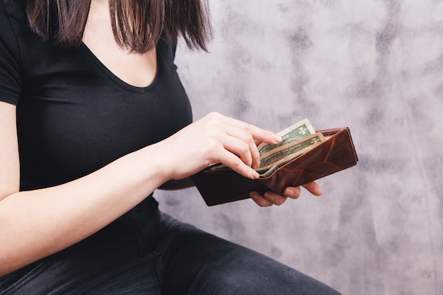 Photo young woman puts money in wallet