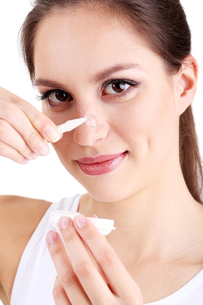 Young woman putting contact lens in her eye close up