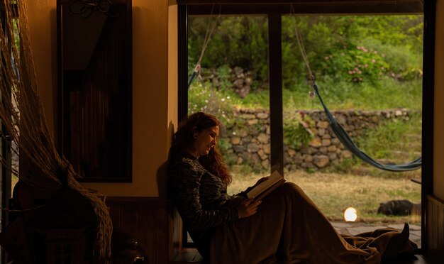 young woman in the quiet twilight reading a book