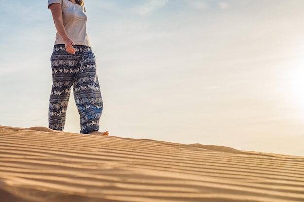 Young woman in rad sandy desert at sunset or dawn