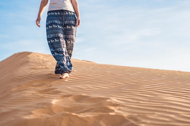 Young woman in rad sandy desert at sunset or dawn