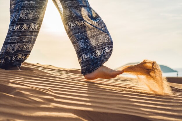 Young woman in rad sandy desert at sunset