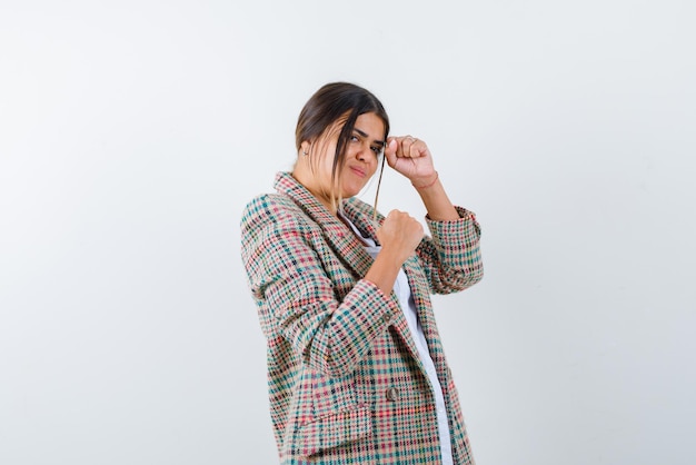 Young woman raising her fists on white background