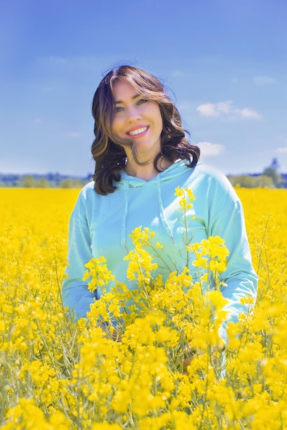 ウクライナの旗のような菜種畑黄青背景の若い女性